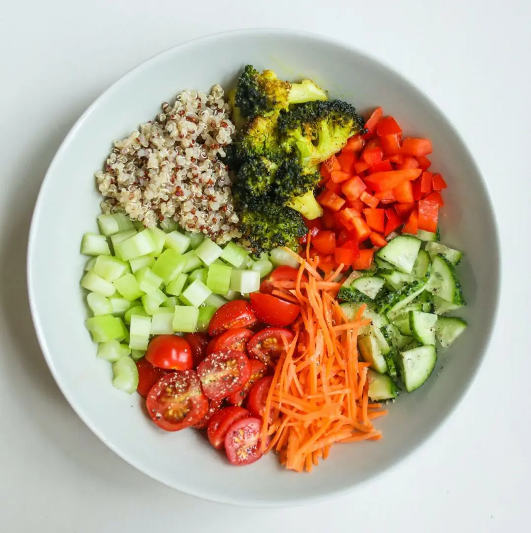 A bowl of food with different vegetables and grains.